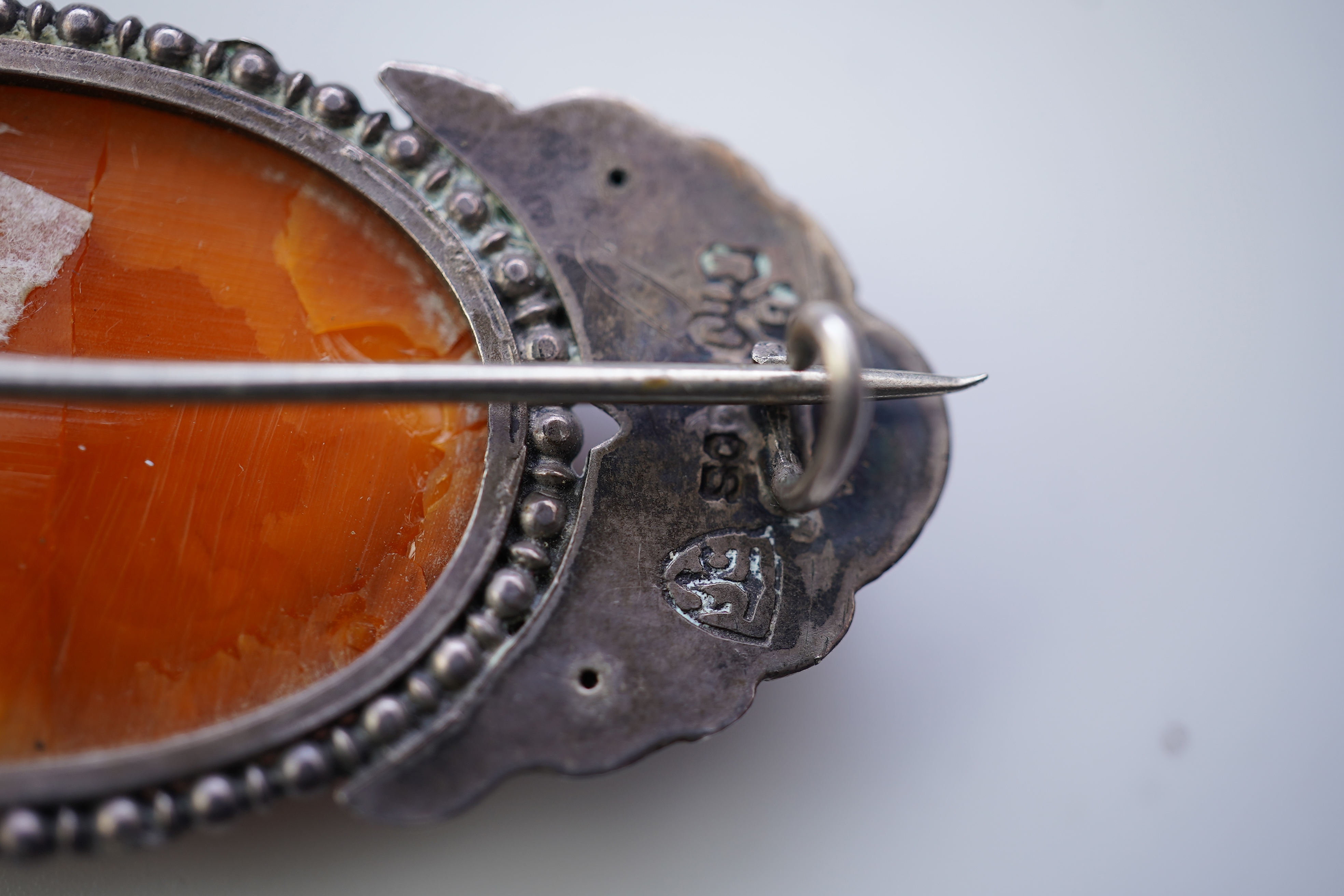 Three Arts & Crafts silver and amber brooches, early 20th century